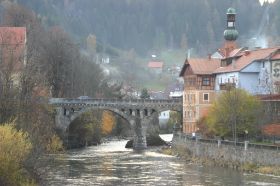 Murau: die Uferpromenade, im Hintergrund eine Skisprungschanze